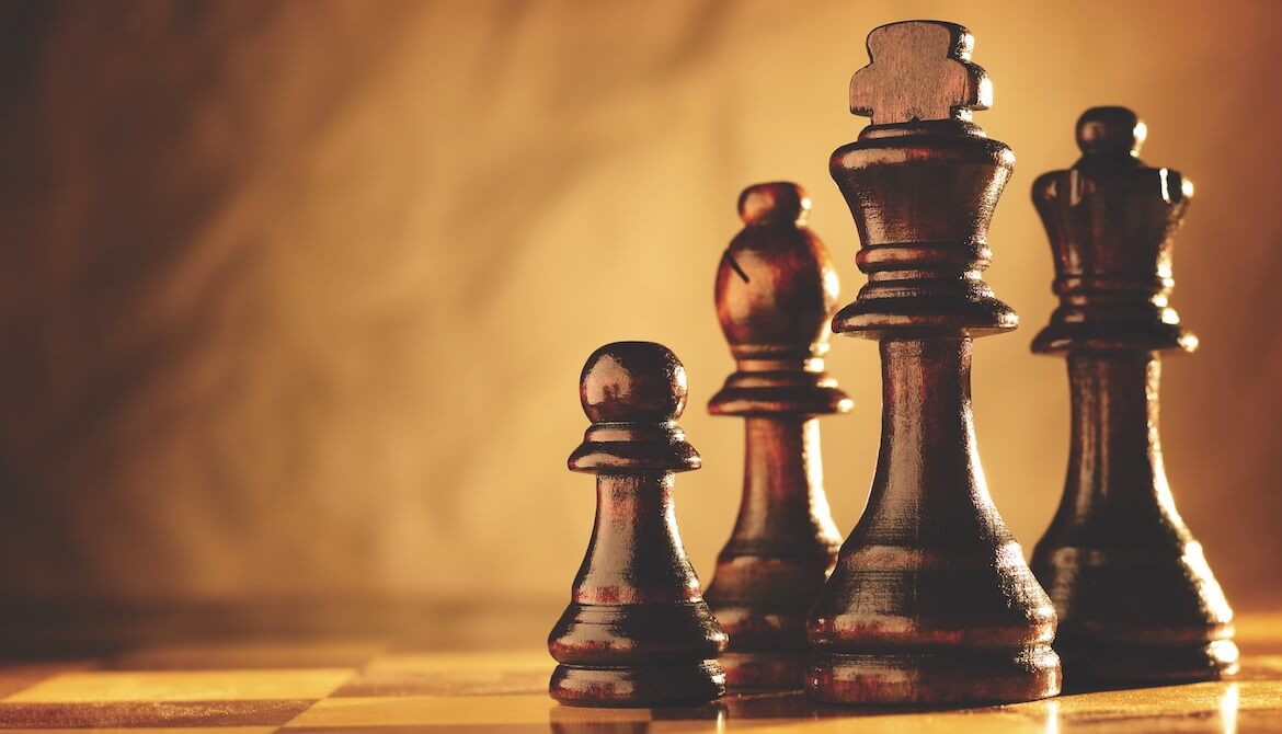 set of polished brown wooden chess pieces on a matching board