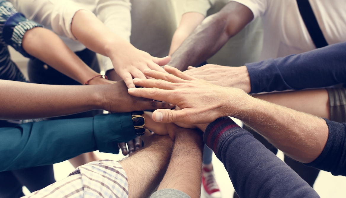 hands together in a circle as for teamwork and diversity