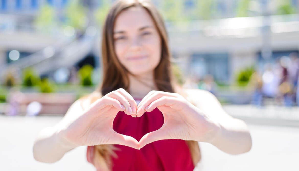 girl makes a heart shape with her hands