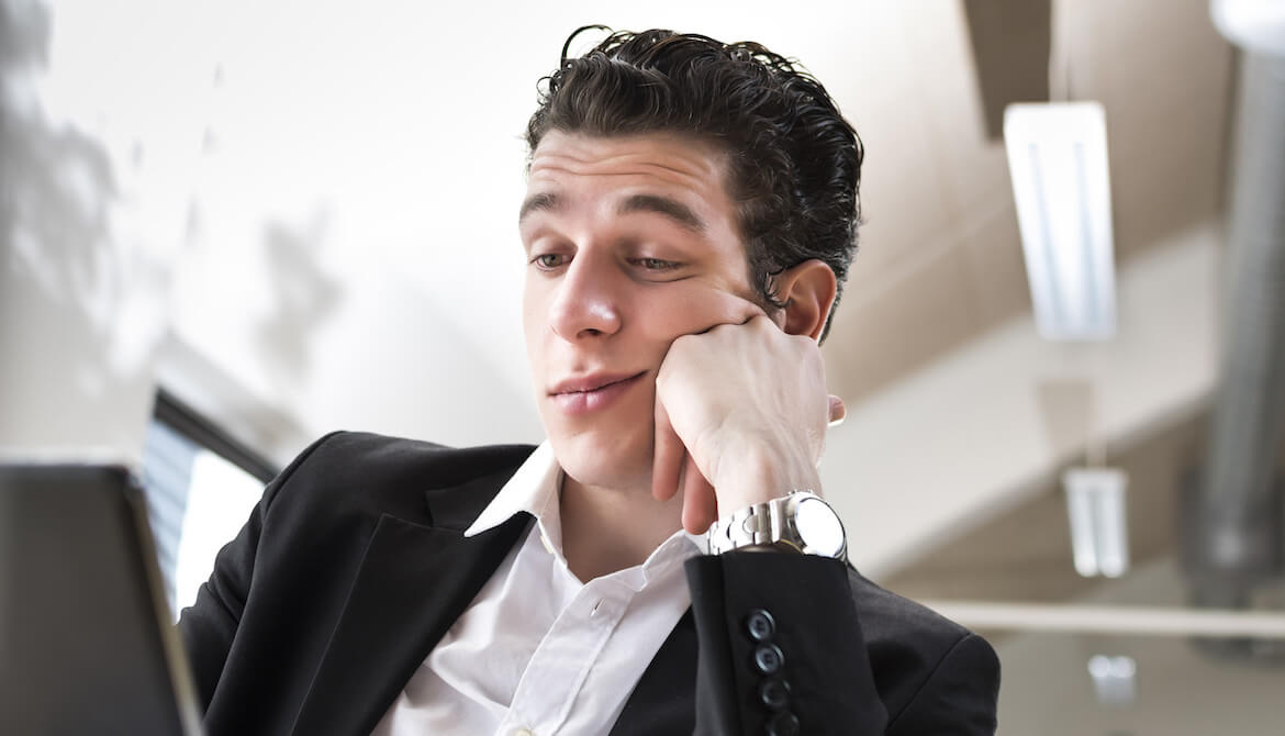 male business employee is bored in front of his computer shows lack of engagement commitment to job