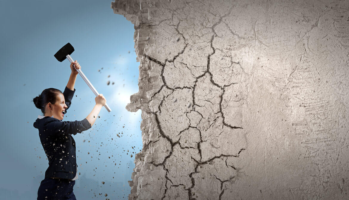 woman using sledgehammer to break down wall