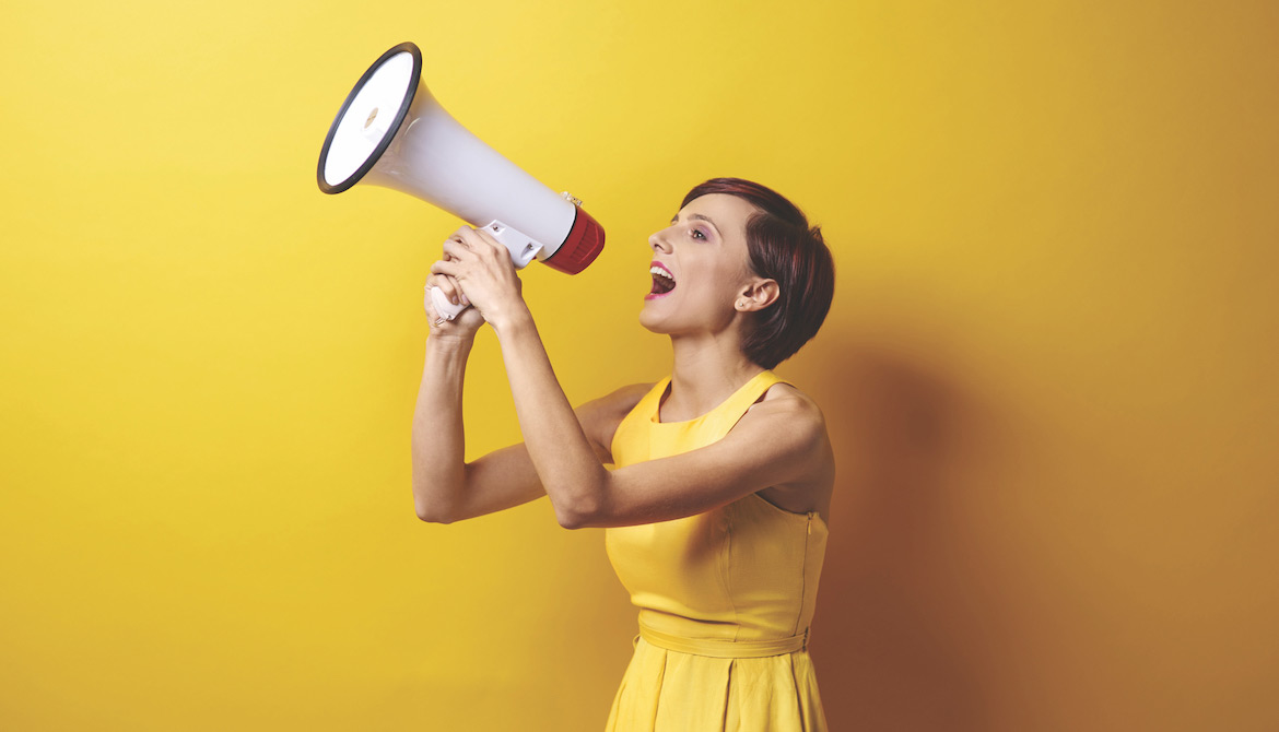 woman in a yellow dress using a bullhorn or megaphone