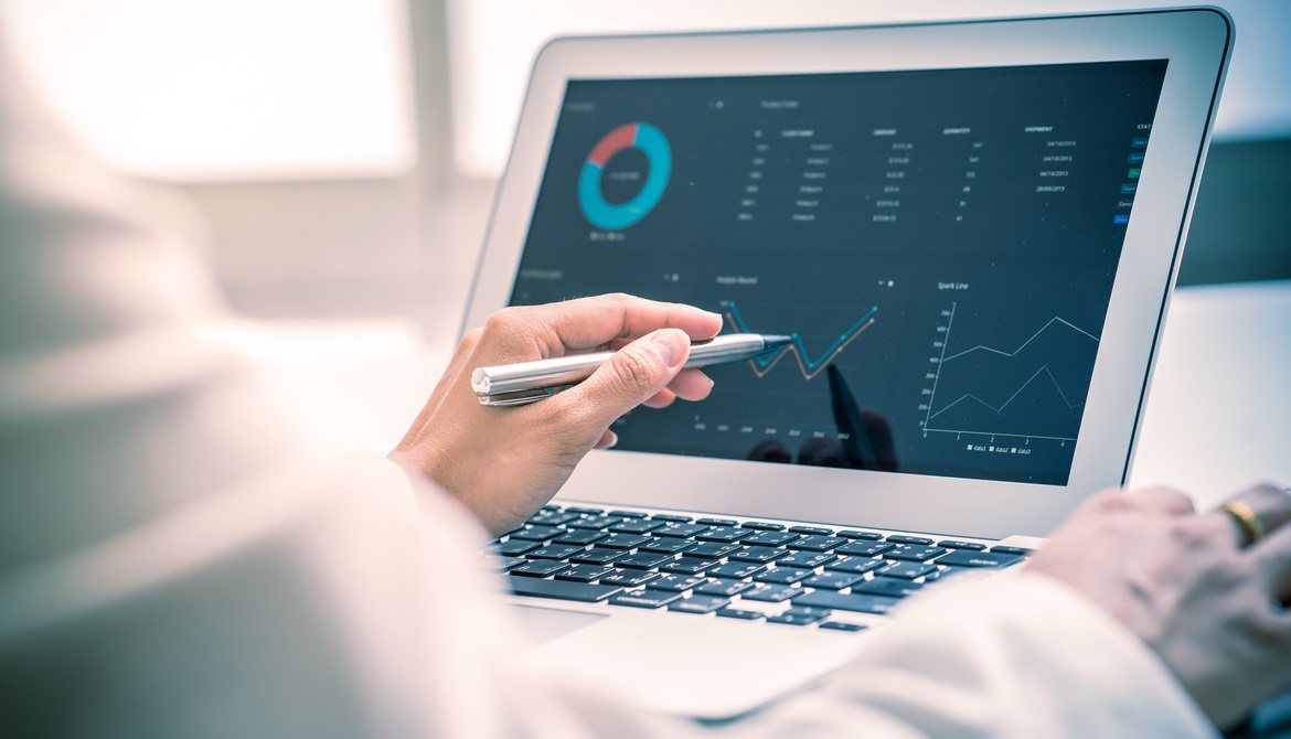 woman using a computer to consider merger financials