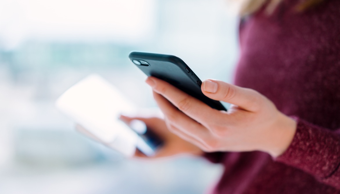 Young woman depositing a check by remote capture with her smartphone