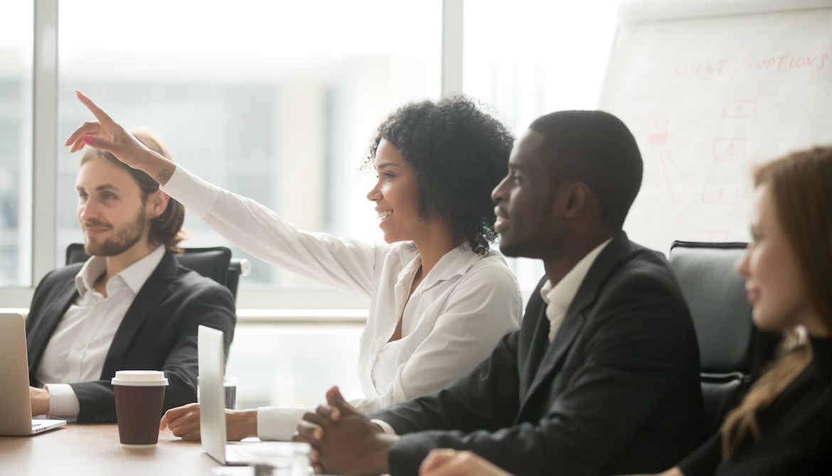 woman raising hand at meeting