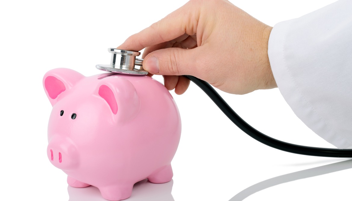 Doctor listening to a piggy bank with a stethoscope