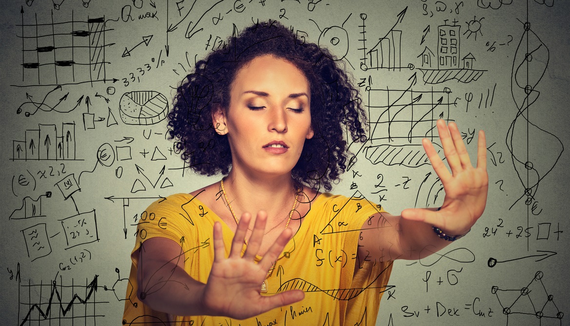 woman in a yellow blouse with eyes closed putting hands out in front onto charts and graphs