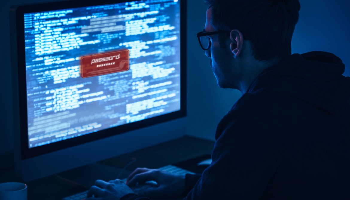 man from back using computer with password on sreen in dark room