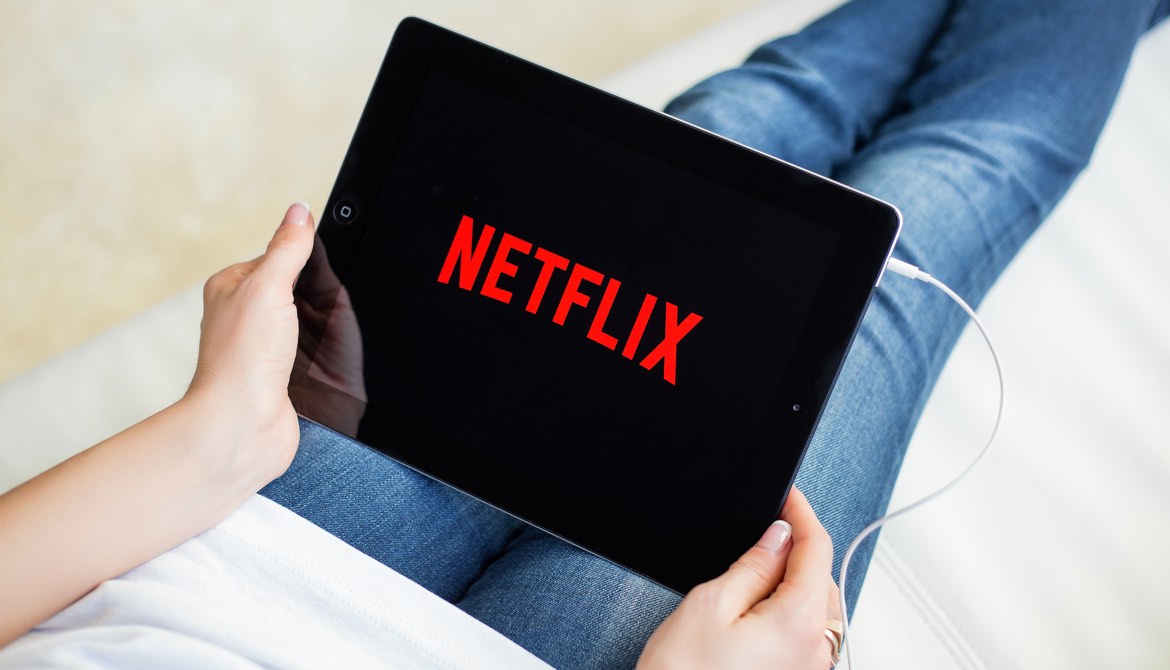 woman holding a tablet with the Netflix logo