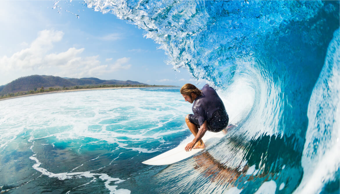 surfer on blue ocean wave in the tube getting barreled