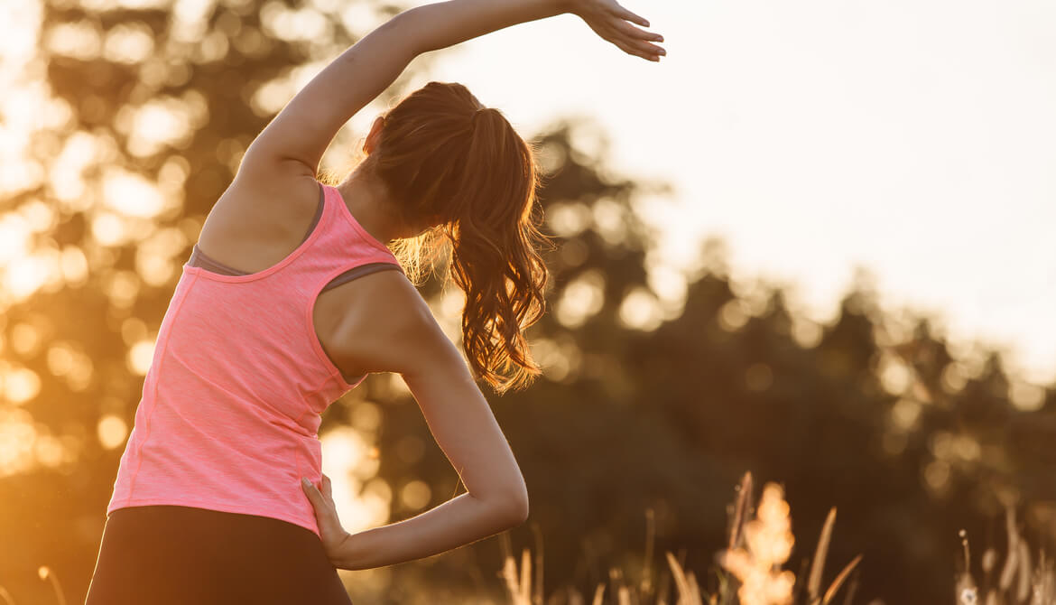 young woman warming up outdoors by stretching