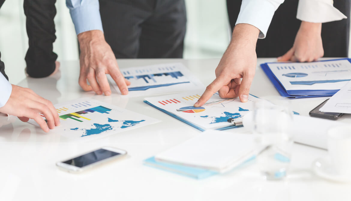 people studying charts and graphs on a table