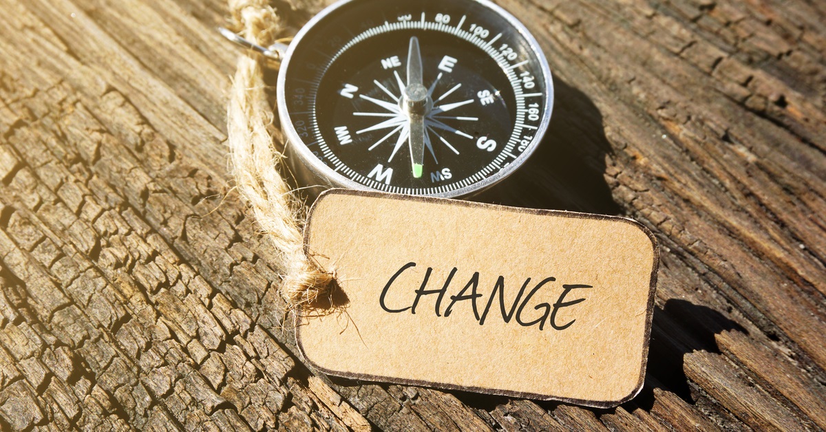 compass and paper tag labeled CHANGE sitting on old wood