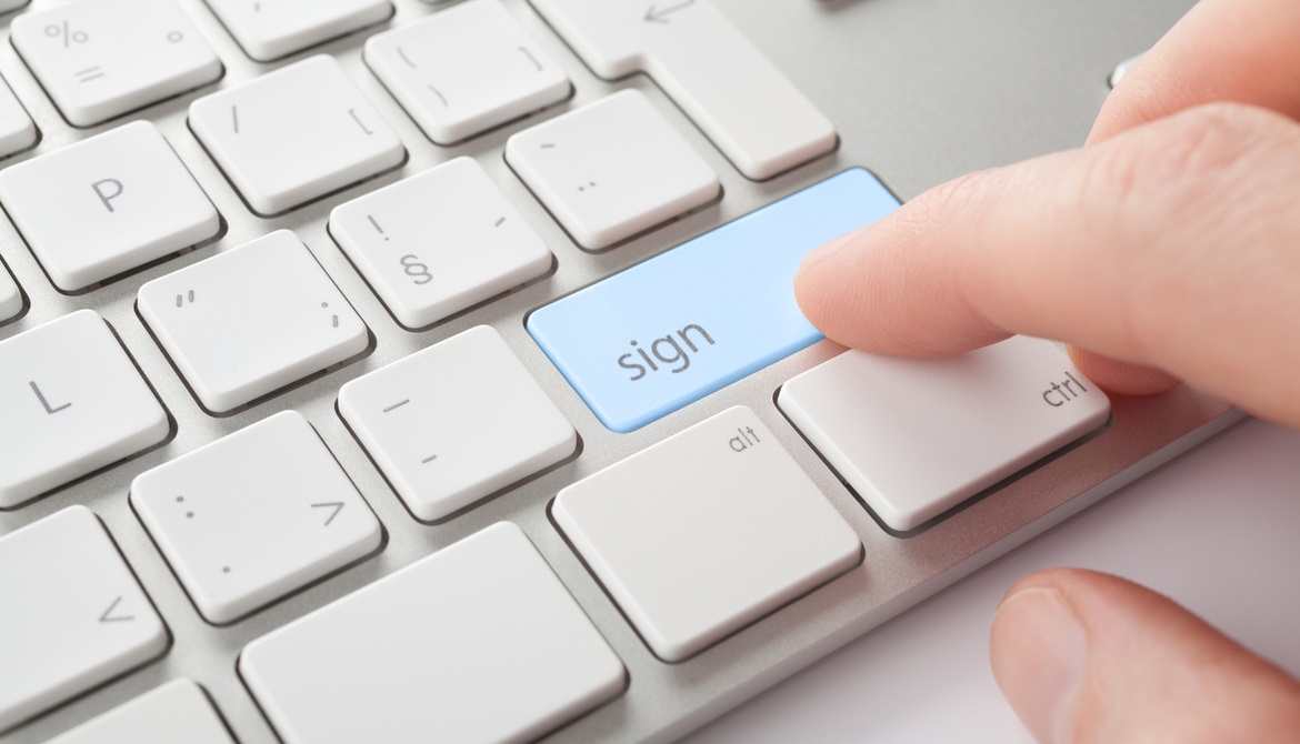 Fingers choosing the sign button on a keyboard