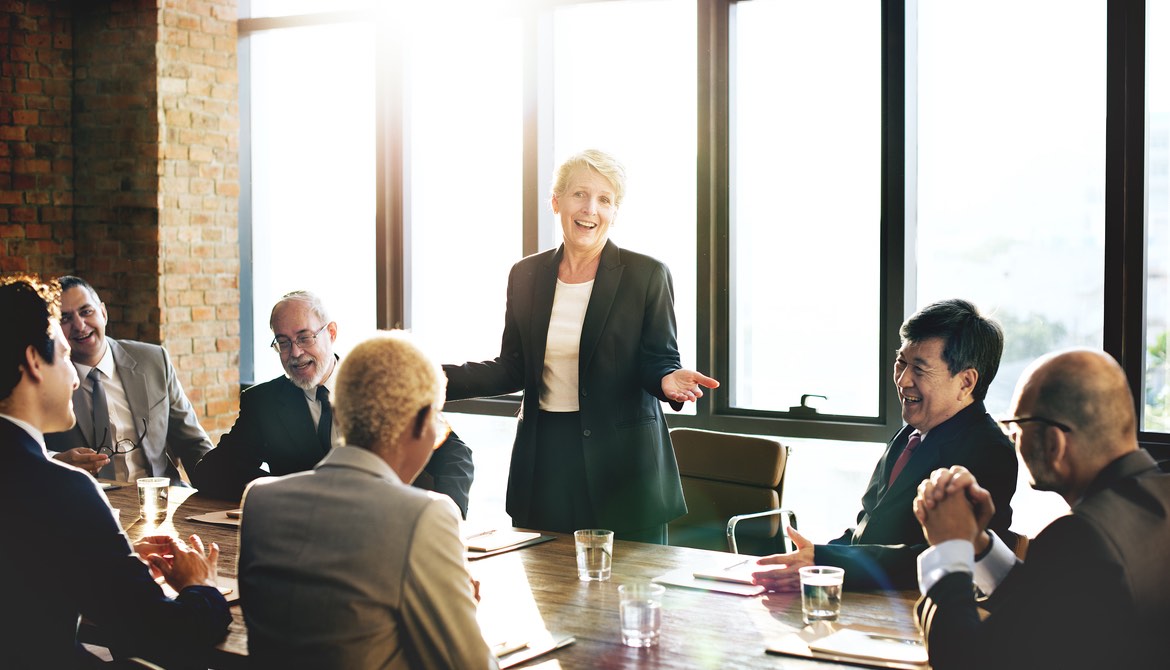 female board chair addresses directors during board meeting