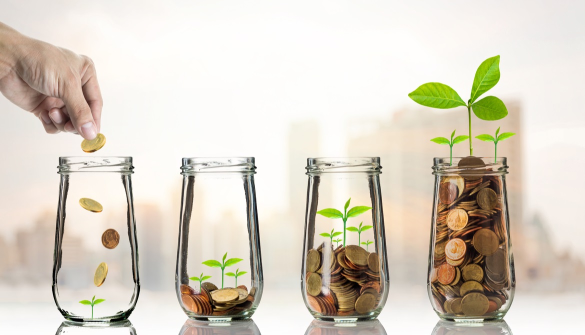 Hand putting Gold coins and seed in clear bottle