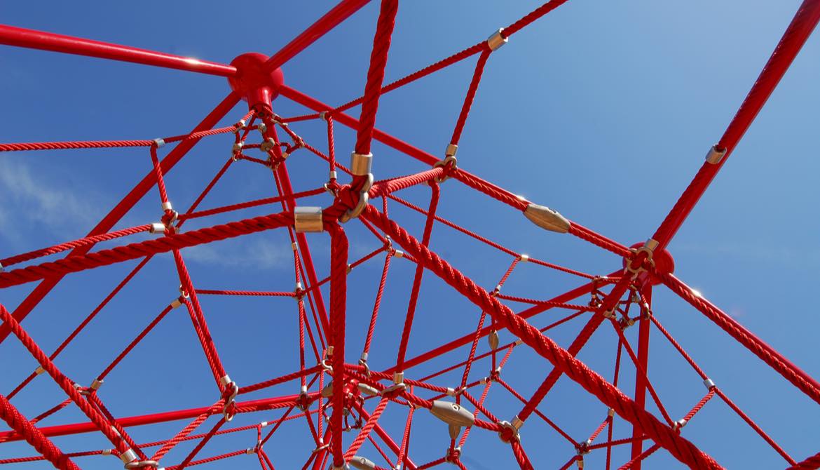 red jungle gym on blue sky