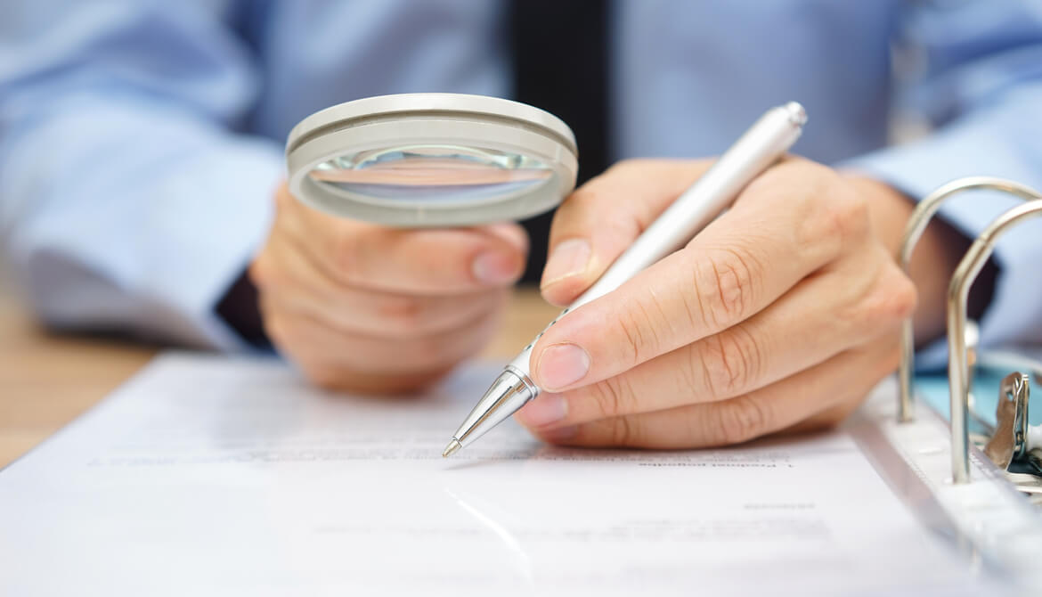 businessman analyzing through magnifying glass