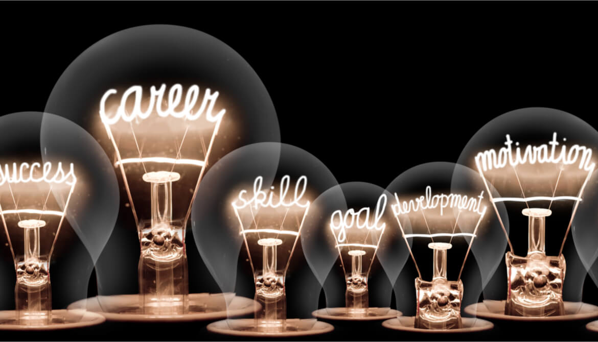 lightbulbs with glowing filaments in the shape of career and development related words