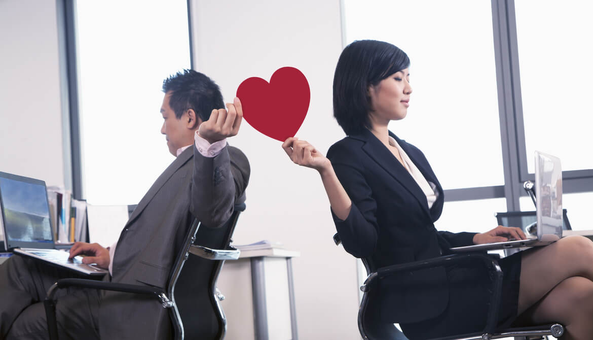 executives passing a red paper heart between their workspaces