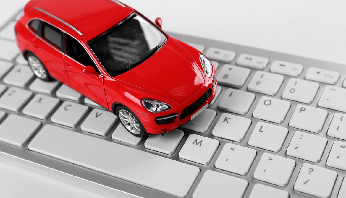 red toy car sits on white computer keyboard