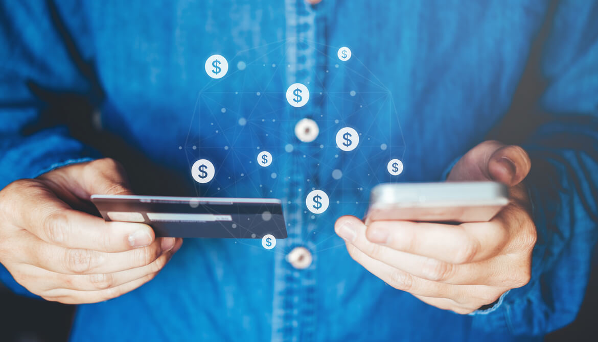 man using smartphone with credit card and dollar signs