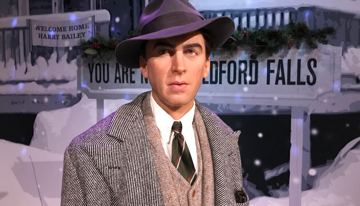 Jimmy Stewart figure in front of Bedford Falls sign from It’s a Wonderful Life