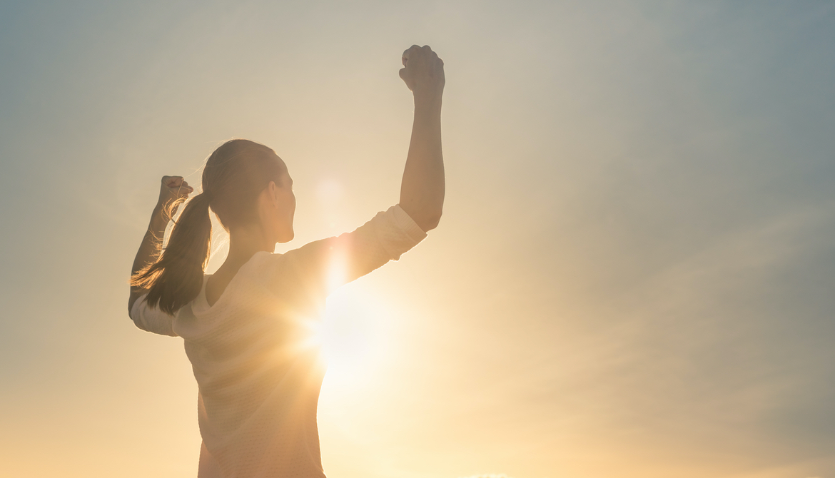 confident woman in front of sunset