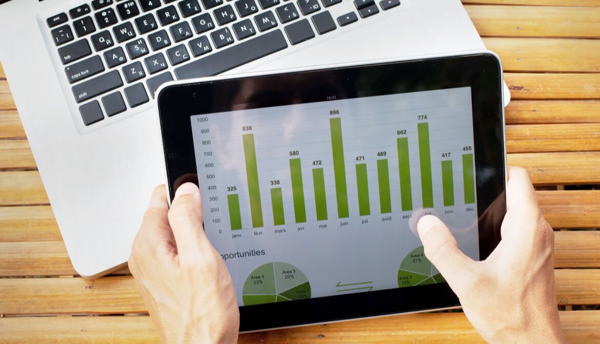 hands on tablet with charts