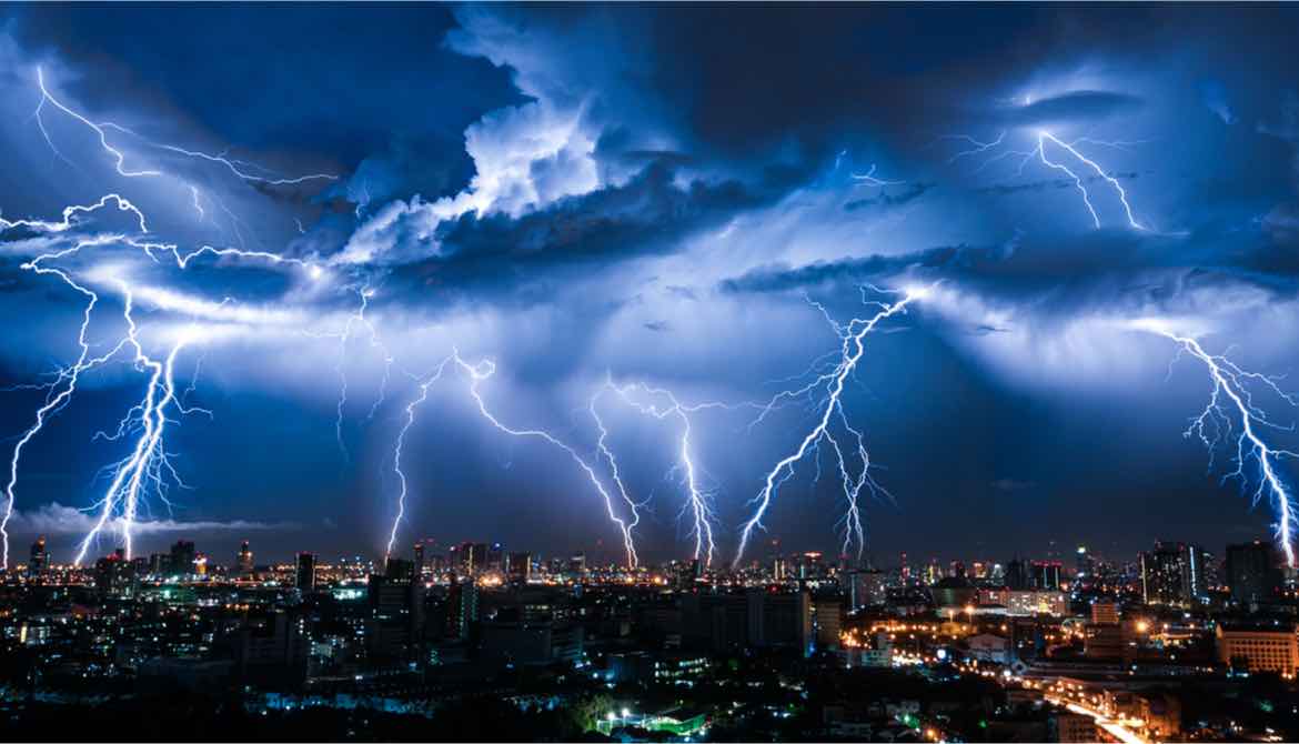 Lightning storm over city in purple light