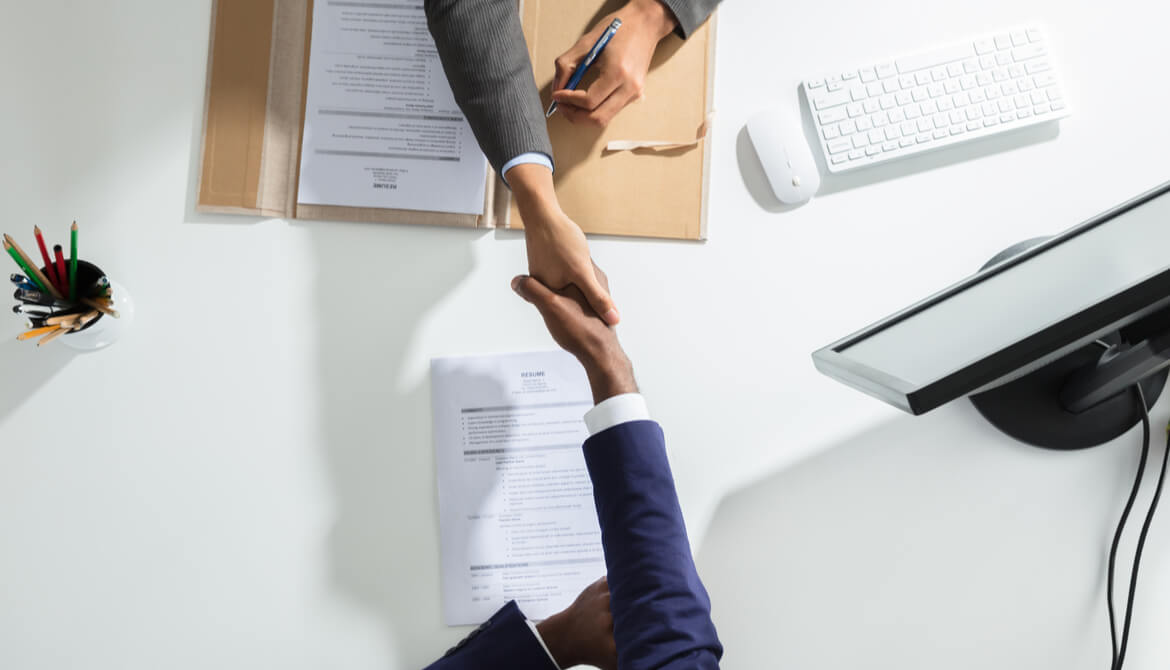 high-angle shot of two businesspeople shaking hands across a table