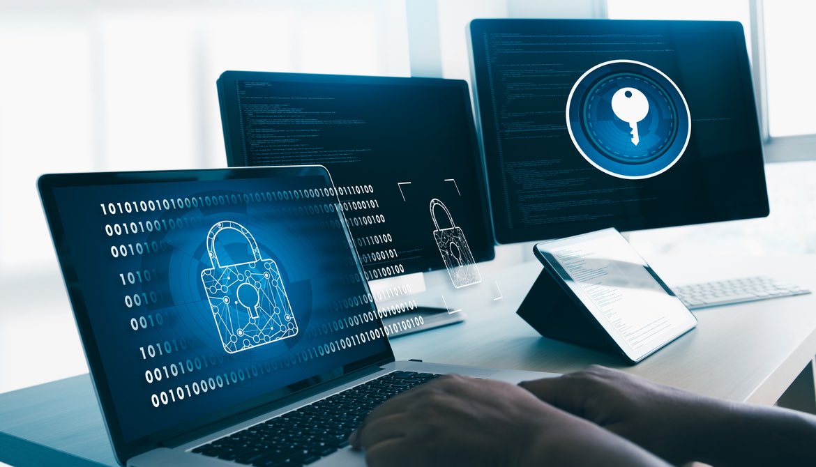 man working with three screens showing locks and data