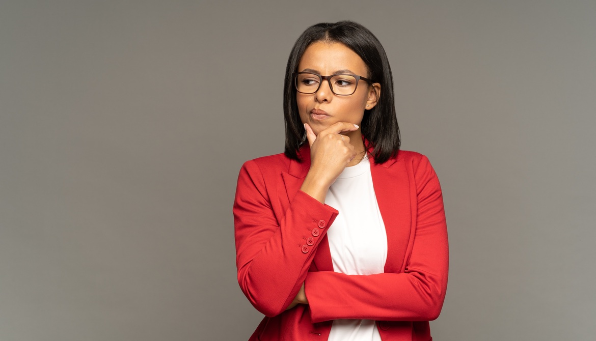 female executive in red sweater thinking