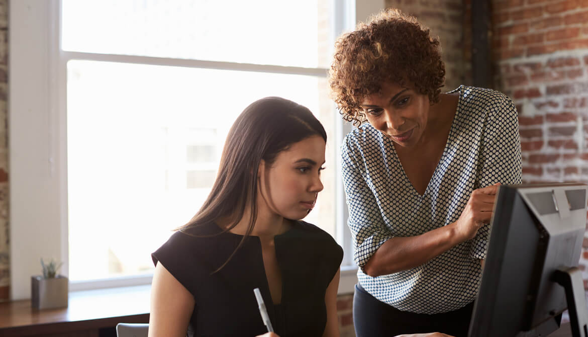 Black businesswoman leader mentoring a young female colleague at the office