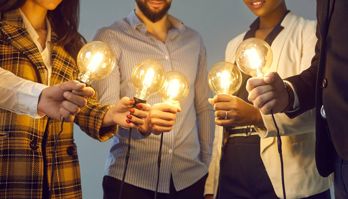 young multiethnic business team holding light bulbs