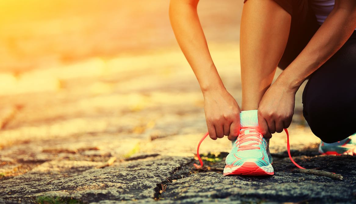 tying athletic shoe