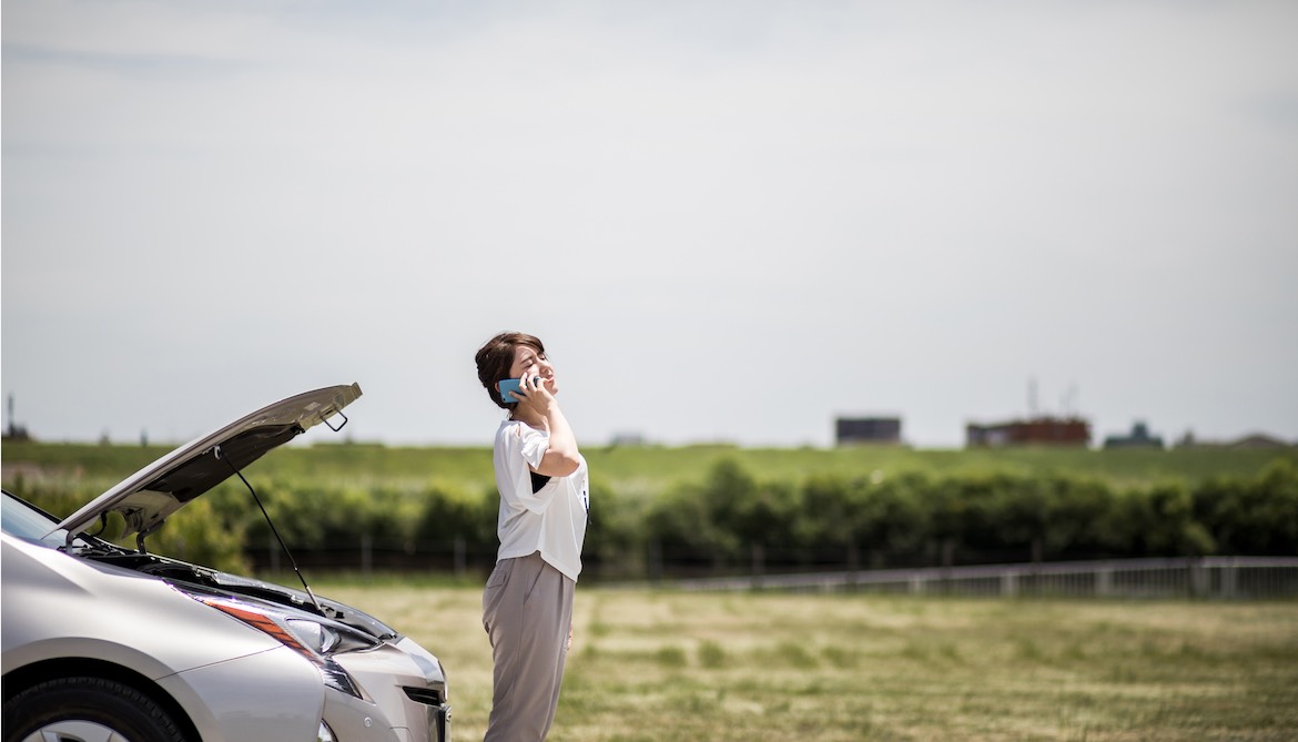 woman with phone and stalled car 