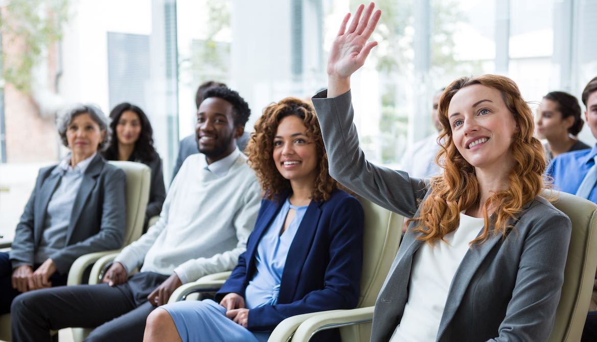 female executive raising hand meeting