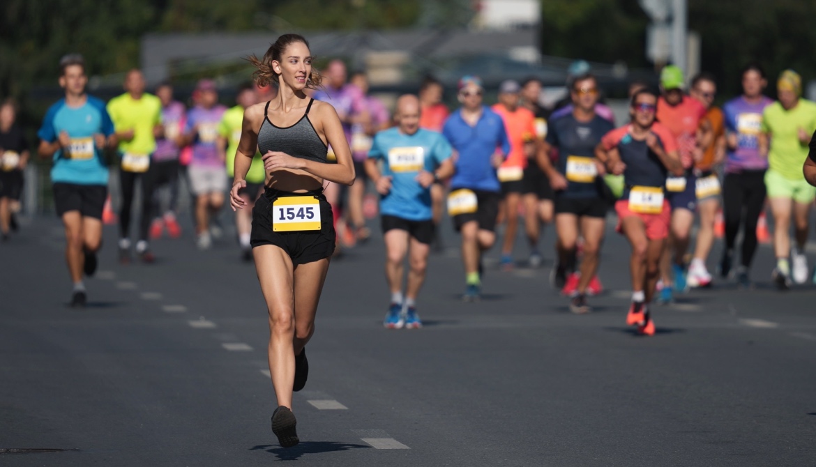 A female runner is ahead of the pack during a running race