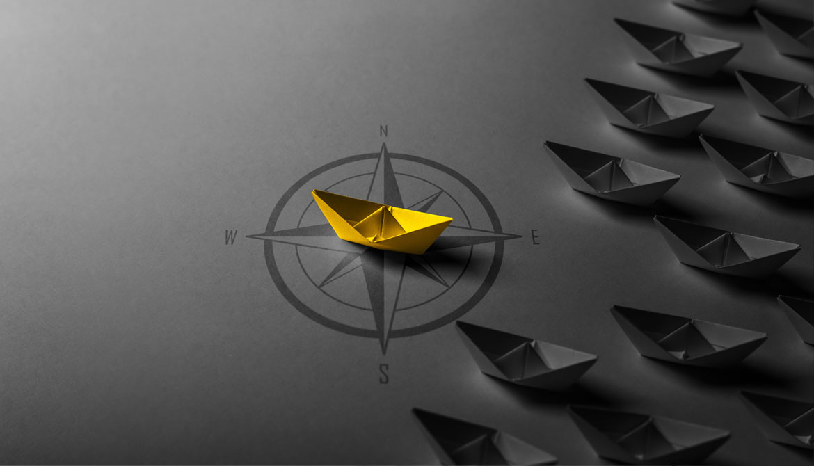 paper boat on compass