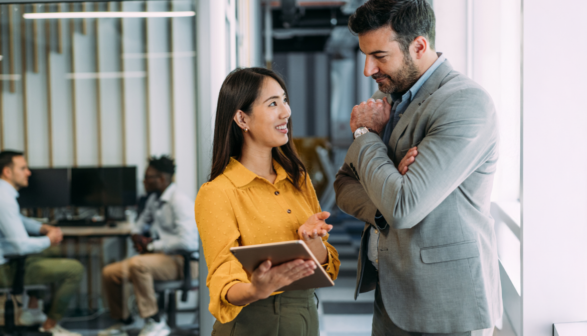 man and woman talking in office