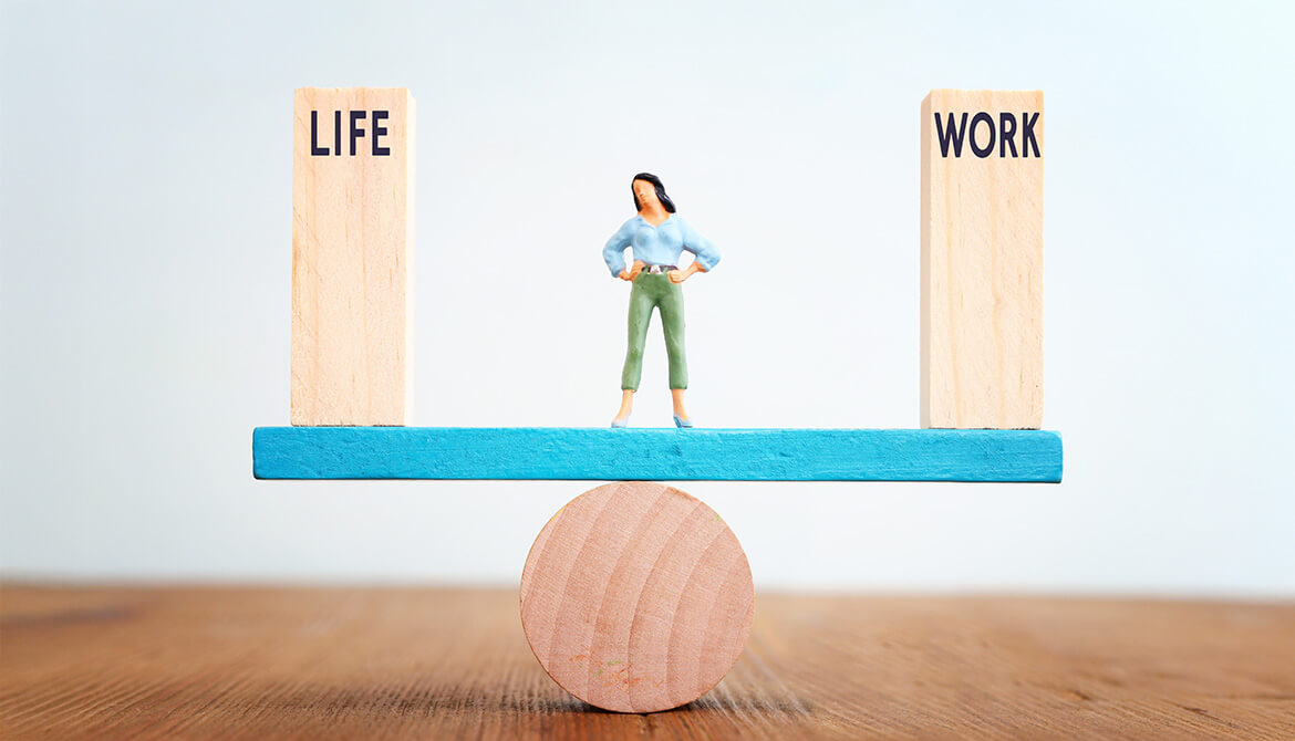 woman balancing work and life blocks on a seesaw