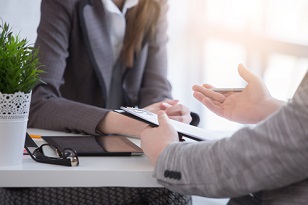 HR person conducting an exit interview, notepad in hand