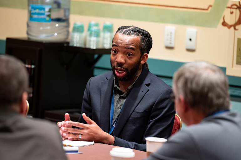 a young director participants in a discussion at a conference table