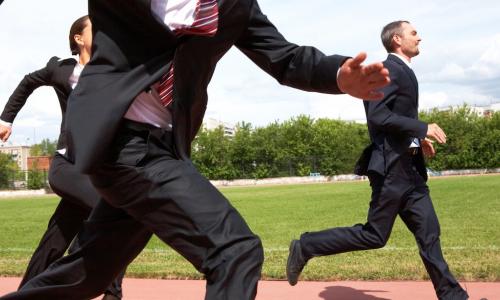 businesspeople racing and keeping pace around a track