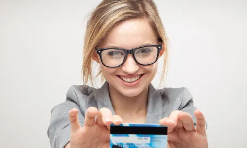 happy young business woman holding a new credit or debit card