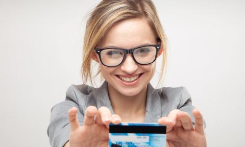 happy young business woman holding a new credit or debit card