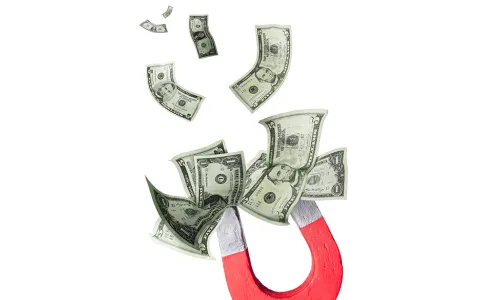 Horseshoe magnet attracting numerous $1 and $5 bills