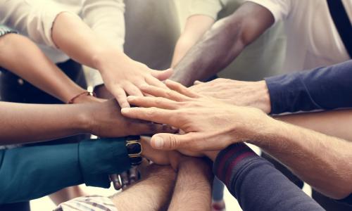 hands together in a circle as for teamwork and diversity