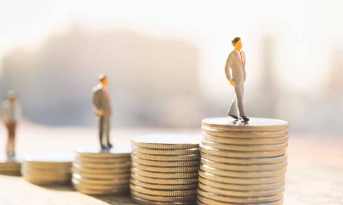 piles of coins with businessmen figurines on top